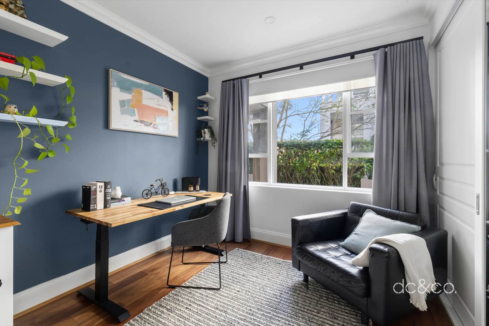 Second bedroom set up as a home office with a desk and armchair